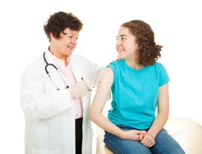 Teen girl gets a vaccination from a caring female doctor.  Isolated on white.