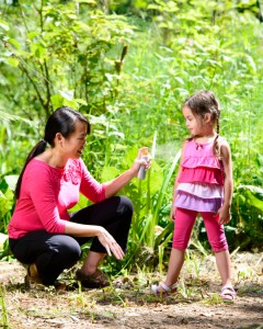 Mother Applying Bug Spray To Daughter