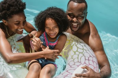 Mother, father, and daughter enjoying the pool while adhering to pool safety