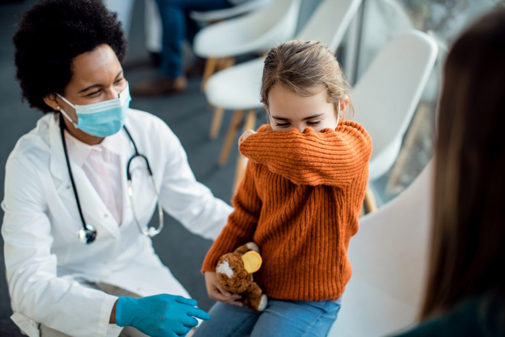 child has a cough as a doctor looks on